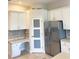 Bright kitchen featuring white cabinets, stainless steel refrigerator, and tiled backsplash at 2980 Seasons Blvd, Sarasota, FL 34240