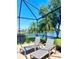 Relaxing screened patio featuring views of the waterfront and comfortable lounge seating at 2980 Seasons Blvd, Sarasota, FL 34240