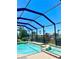 Inviting pool featuring an attached hot tub, all set within a screened-in enclosure at 2980 Seasons Blvd, Sarasota, FL 34240