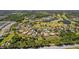 Aerial view displaying an attractive neighborhood featuring a lush golf course, mature trees, and multiple lakes at 3816 Little Country Rd, Parrish, FL 34219