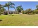 Spacious backyard showcasing well-kept lawn, mature trees, and screened-in patio at 3816 Little Country Rd, Parrish, FL 34219