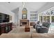 Bright living room with fireplace and built-in shelving overlooking screened pool at 3816 Little Country Rd, Parrish, FL 34219