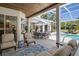 Inviting covered patio with dining set, lounge chairs, and serene pool view at 3816 Little Country Rd, Parrish, FL 34219