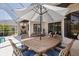 Covered patio dining area offers a relaxing space with seating and serene pool views at 3816 Little Country Rd, Parrish, FL 34219