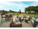 Inviting patio with wicker furniture and red umbrellas overlooking the pristine golf course at 3816 Little Country Rd, Parrish, FL 34219
