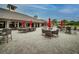 Outdoor patio with brick pavers, umbrella-covered tables, and charming wicker chairs at 3816 Little Country Rd, Parrish, FL 34219