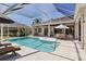 Screened-in pool with sunny patio, featuring lounge chairs and a tropical landscape view at 3816 Little Country Rd, Parrish, FL 34219