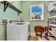 Functional laundry room with modern washer, dryer, and ample shelving at 426 Magnolia Ave, Anna Maria, FL 34216
