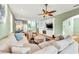 Spacious living room with a large sectional, built-in shelving, hardwood floors, and neutral coastal tones at 426 Magnolia Ave, Anna Maria, FL 34216