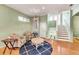 Cozy living room with light green walls, hardwood floors, staircase, and nautical-themed decor accents at 426 Magnolia Ave, Anna Maria, FL 34216