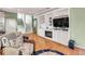 Inviting living room with custom built-ins, hardwood floors, coastal decor, and staircase access at 426 Magnolia Ave, Anna Maria, FL 34216