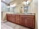 Bathroom featuring a granite vanity with double sinks and a large framed mirror at 4721 Turnberry Cir, North Port, FL 34288