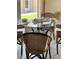 Close up view of dining table with wicker chairs, and a view of the lanai and backyard at 4721 Turnberry Cir, North Port, FL 34288