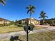 Well-maintained single-story house with palm trees and lush lawn, with brick paver driveway on a sunny day at 4721 Turnberry Cir, North Port, FL 34288