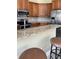 Granite countertops, stainless appliances, and wood cabinetry complement this kitchen with bar seating at 4721 Turnberry Cir, North Port, FL 34288
