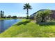 Expansive backyard with lush lawn, bordered by a serene lake, offering picturesque outdoor living at 4918 Avon Ln, Sarasota, FL 34238