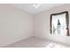 Bedroom features tile flooring, a ceiling fan, and a window with decorative curtains at 4918 Avon Ln, Sarasota, FL 34238