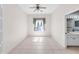 This cozy bedroom features tile flooring, a ceiling fan, and a window with decorative curtains at 4918 Avon Ln, Sarasota, FL 34238