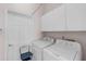 Functional laundry room featuring a washer, dryer, and overhead storage cabinets for convenience at 4918 Avon Ln, Sarasota, FL 34238