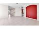 Bright and open living area with tile flooring, a red accent wall and view to other rooms at 4918 Avon Ln, Sarasota, FL 34238