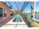 Outdoor pool area features an in-ground pool, screened enclosure and a beautiful pond view at 4918 Avon Ln, Sarasota, FL 34238