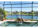 Close-up of sparkling pool featuring a rock waterfall and beautiful views of the surrounding pond and neighborhood at 4918 Avon Ln, Sarasota, FL 34238