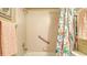 Well-lit bathroom with a tropical shower curtain and convenient grab bars for safety at 525 Barcelona Ave # 207, Venice, FL 34285