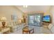 Comfortable living room with neutral walls, patio access, and carpeted floors at 525 Barcelona Ave # 207, Venice, FL 34285
