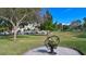 Lush green lawn with a gazebo, shade trees, and a metal flower sculpture in a serene park at 525 Barcelona Ave # 207, Venice, FL 34285