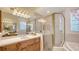 Well-lit bathroom featuring a glass shower enclosure, bathtub, and vanity with a large mirror at 5355 Anthony Ln, Sarasota, FL 34233