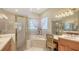 Bright bathroom showcasing a shower, soaking tub, double vanity, and well-lit mirror at 5355 Anthony Ln, Sarasota, FL 34233