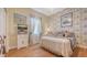 Cozy bedroom with hardwood floors, decorative wallpaper, and a classic dresser at 5355 Anthony Ln, Sarasota, FL 34233