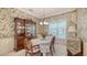Formal dining room features china cabinet, floral wallpaper, and soft natural lighting at 5355 Anthony Ln, Sarasota, FL 34233