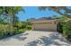A two-car garage with a concrete driveway and lush landscaping provides excellent curb appeal at 5355 Anthony Ln, Sarasota, FL 34233