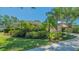 Home exterior view featuring lush tropical landscaping, a manicured lawn, and a tile roof at 5355 Anthony Ln, Sarasota, FL 34233