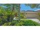 Home featuring a well-manicured front yard with beautiful landscaping and a tile roof at 5355 Anthony Ln, Sarasota, FL 34233