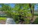 Landscaped pathway features colorful tropical flowers, lush greenery, and mature trees at 5355 Anthony Ln, Sarasota, FL 34233