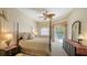 Inviting main bedroom with a four-poster bed, decorative ceiling fan, and serene pool views at 5355 Anthony Ln, Sarasota, FL 34233