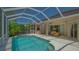A screened-in lanai that showcases the pool area with outdoor seating, providing a tranquil view at 5355 Anthony Ln, Sarasota, FL 34233