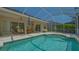 Inviting screened pool with poolside seating and a glimpse of the home's charming patio area at 5355 Anthony Ln, Sarasota, FL 34233