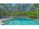 Inviting screened-in pool with clear blue water, surrounded by lush greenery at 5355 Anthony Ln, Sarasota, FL 34233