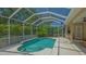 Sparkling pool within screened enclosure with lush landscaping, perfect for relaxing outdoors at 5355 Anthony Ln, Sarasota, FL 34233