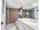 Well-lit bathroom featuring white vanity, floral wallpaper, walk-in shower, and large mirror at 5432 Cape Leyte Dr, Sarasota, FL 34242