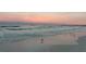 Scenic beach view with calm waves, birds, and a colorful sunset sky at 5432 Cape Leyte Dr, Sarasota, FL 34242