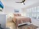Airy bedroom features shuttered windows, ceiling fan, and view of the beautifully landscaped grounds at 5432 Cape Leyte Dr, Sarasota, FL 34242