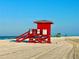A red lifeguard stand on the sandy beach under a clear blue sky at 5432 Cape Leyte Dr, Sarasota, FL 34242