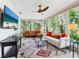 Bright living room with large windows offering lush green views, stylish sofas, patterned rug, and mounted TV at 5432 Cape Leyte Dr, Sarasota, FL 34242