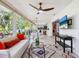 Bright living room with dining area, tile flooring, and many windows overlooking a lush green view at 5432 Cape Leyte Dr, Sarasota, FL 34242