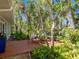 Secluded brick patio featuring an outdoor table surrounded by lush, mature tropical landscaping at 5432 Cape Leyte Dr, Sarasota, FL 34242