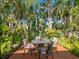 Secluded patio features an outdoor table surrounded by lush, mature tropical landscaping at 5432 Cape Leyte Dr, Sarasota, FL 34242